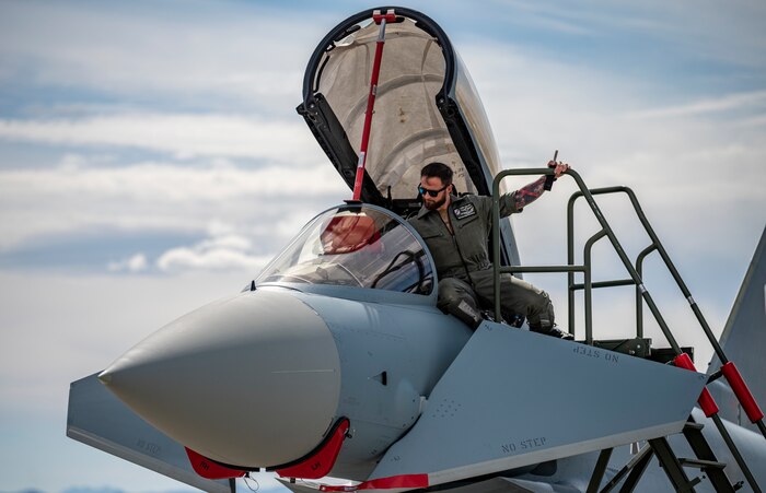 Airman checks cockpit of a jet.