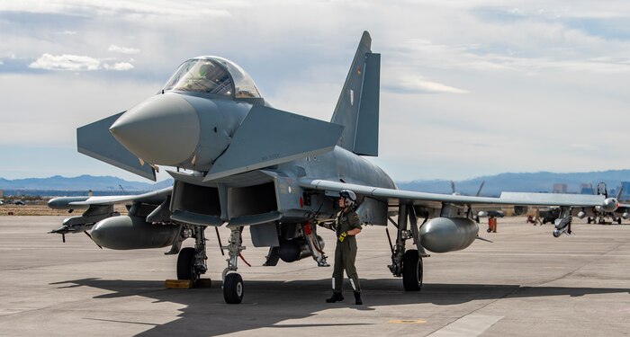 Airman performs pre-flight checks on jet.