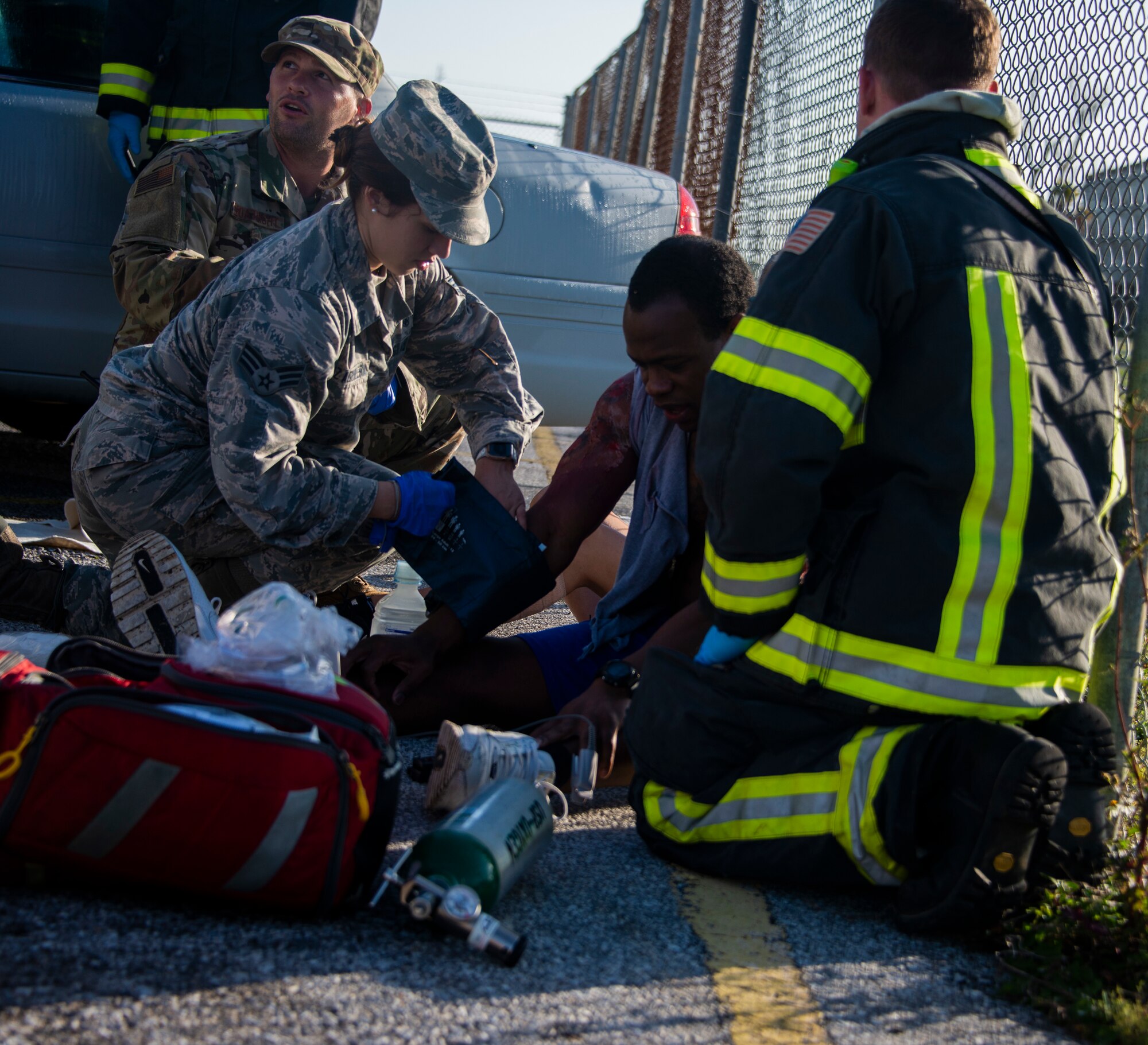 Senior Airman Ashley Deliz Aguilera, 325th Operational Medical Readiness Squadron Ambulance Services Department technician, left, applies emergency medical care to Staff Sgt. Zachary Collins, 325th OMRS ASD technician, center, a simulated patient, during an emergency response exercise at Tyndall Air Force Base, Florida, March 12, 2020. Staff Sgt. Jeffery Wells, 325th Civil Engineer Squadron fire department emergency medical technician, right, also administered medical treatment which is standard prior to patient transfer. (U.S. Air Force photo by 2nd Lt. Kayla Fitzgerald)