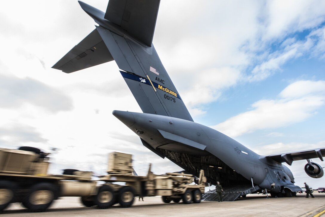A missile launcher is unloaded from an aircraft.