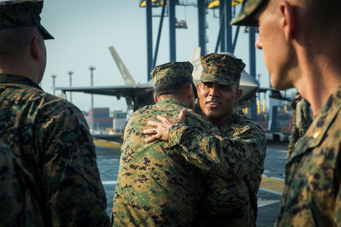 Sgt. Maj. Edwin Mota, offgoing 31st Marine Expeditionary Unit Sergeant Major, hugs a Marine after a relief and appointment ceremony aboard amphibious assault ship USS America March 11.