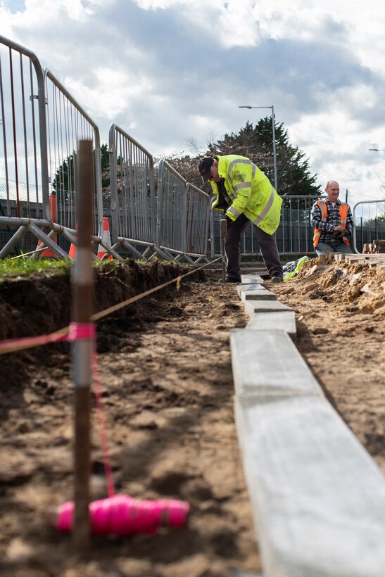 Graham Thornton, 100th Civil Engineer Squadron groundsman, and a member of the pavements and construction equipment shop, hammers a stake into the ground to complete a sidewalk construction project March 11, 2020, at RAF Mildenhall, England. Thornton was part of a team assigned to expand a sidewalk near the child development center. (U.S. Air Force photo by Airman 1st Class Joseph Barron)