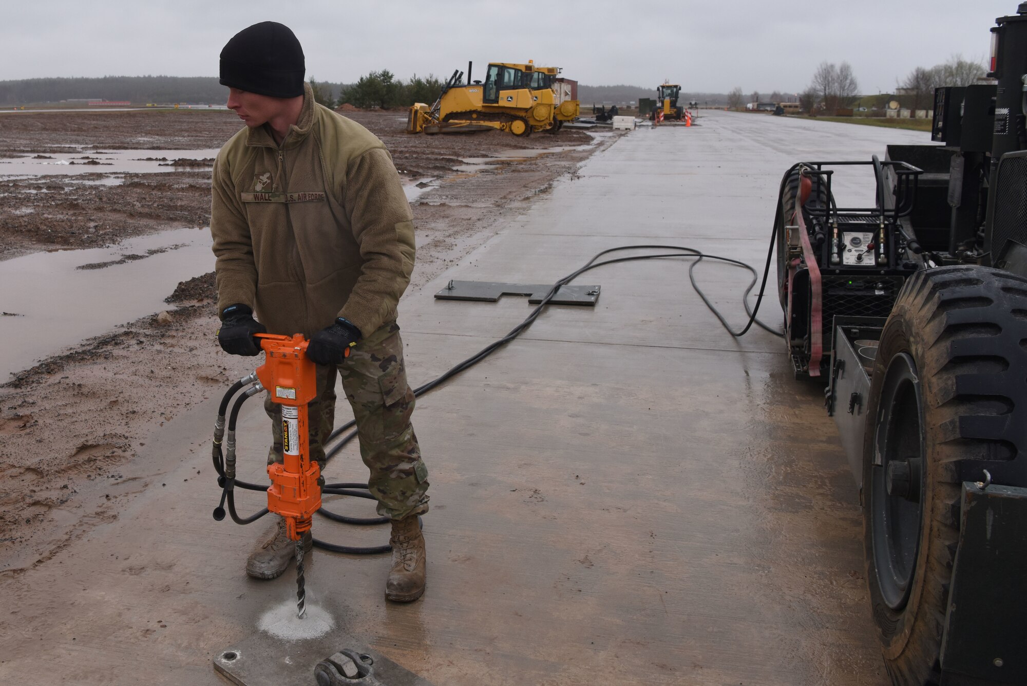 U.S. Airman 1st Class Phillip Wall, 36th Civil Engineer Squadron electrical power production technician, uses a jackhammer during a mobile aircraft arresting system training course at Ramstein Air Base, Germany, March 10, 2020. Wall used the jackhammer to create holes for the bolts that would be used to anchor the arresting system. The training taught Airmen how to effectively build and use mobile aircraft arresting systems, which are used to rapidly decrease the speed of aircrafts as they land.