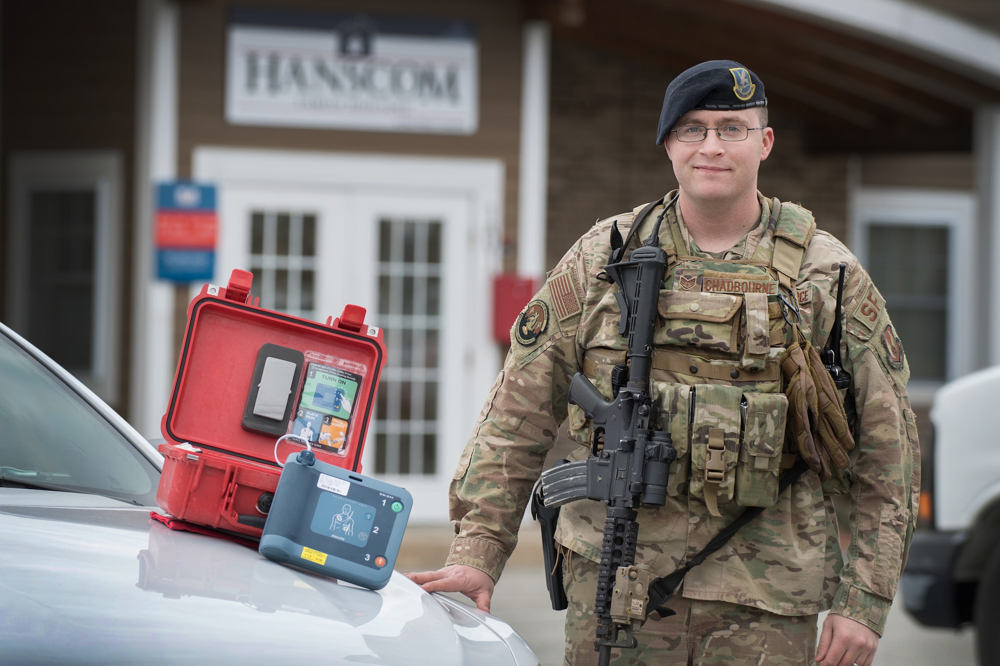 Staff Sgt. Humphrey Chadbourne, 66th Security Forces Squadron patrolman, stands by his cruiser with an automated external defibrillator machine at Hanscom Air Force Base, Mass., March 12. Earlier this year, Chadbourne was the first to respond to a medical emergency where his rapid and decisive actions ultimately saved the life of a contractor who suffered a heart attack on base.  (U.S. Air Force photo by Jerry Saslav)