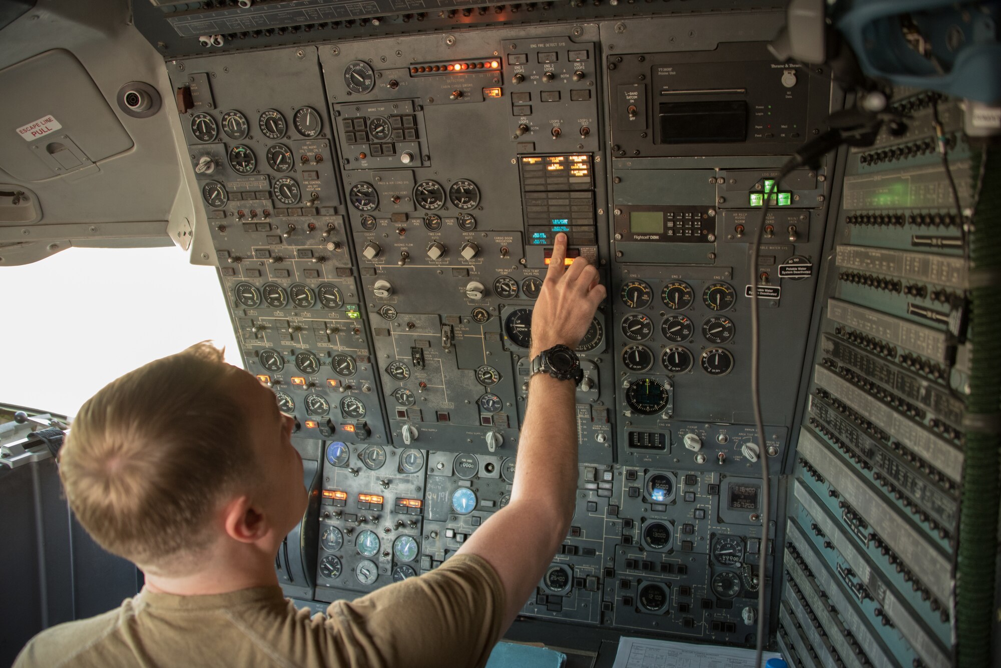 A flight engineer completes preflight procedures on a KC-10