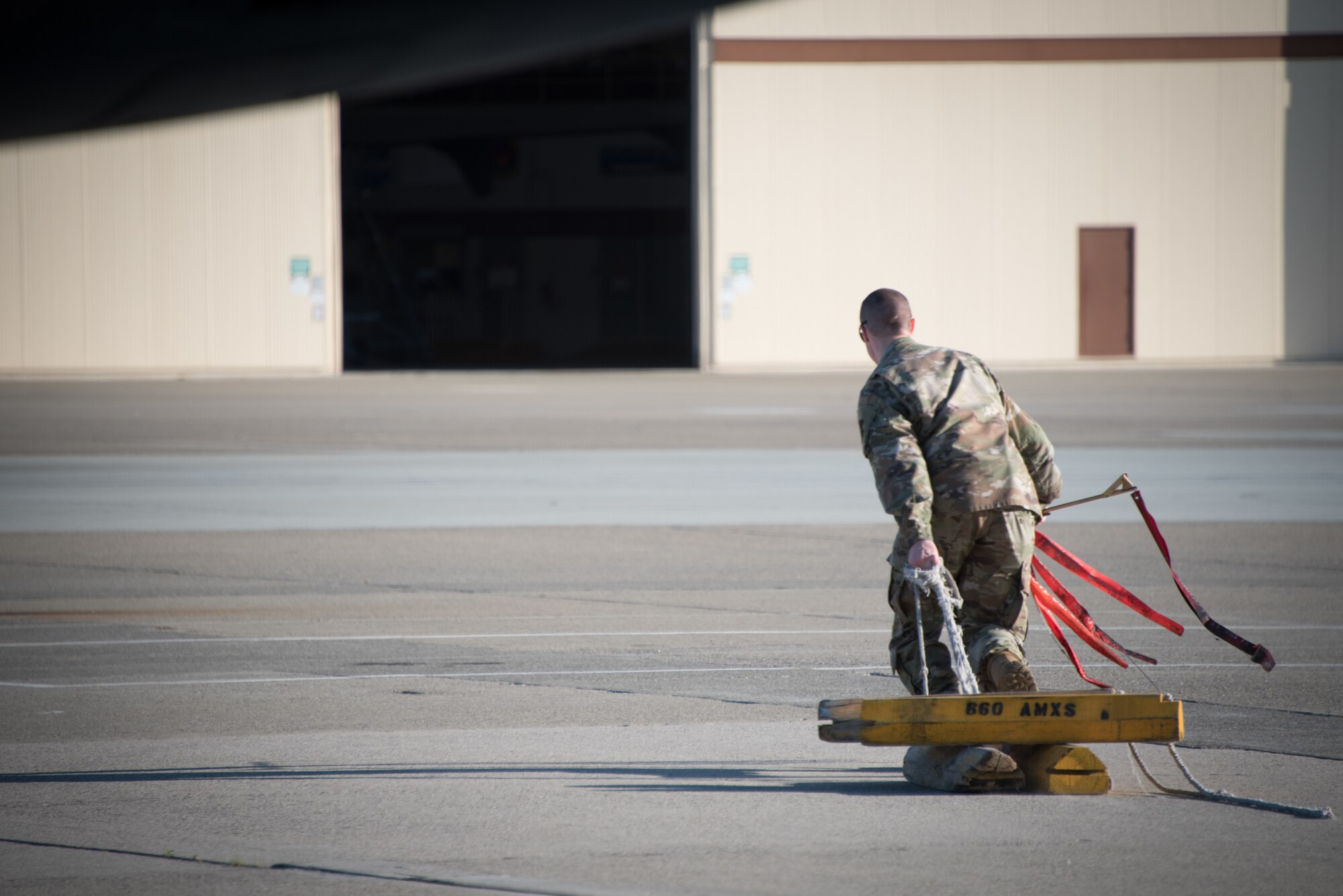 A crew chief pulls chocks from a KC-10 Extender prior to takeoff