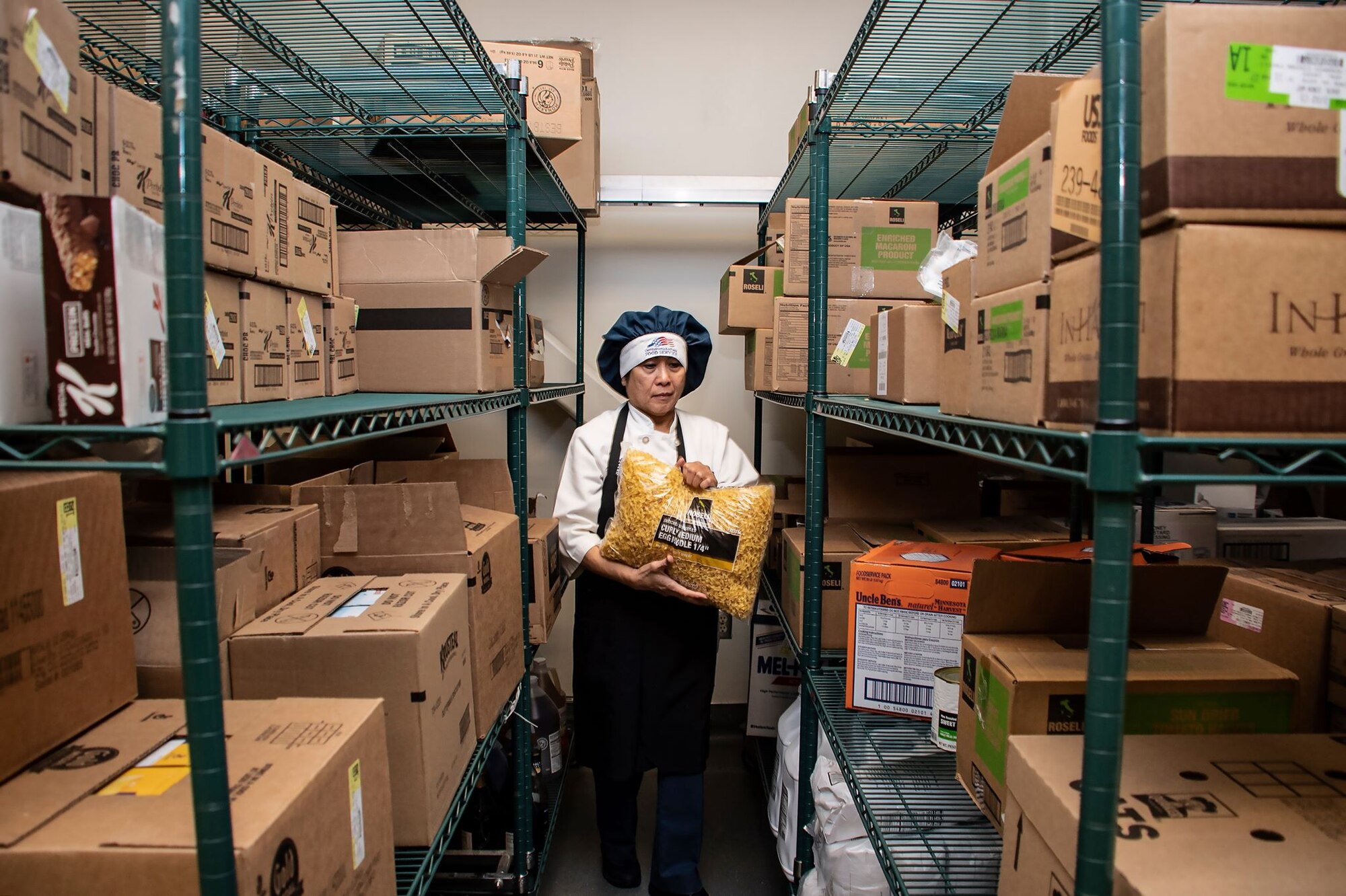 Praxedes Miller, 60th Force Support Squadron cook, gathers ingredients for a lunch service March 11, 2020, at Travis Air Force Base, California. Miller has worked at the base’s dining facility for 31 years. (U.S. Air Force photo by Senior Airman Christian Conrad)