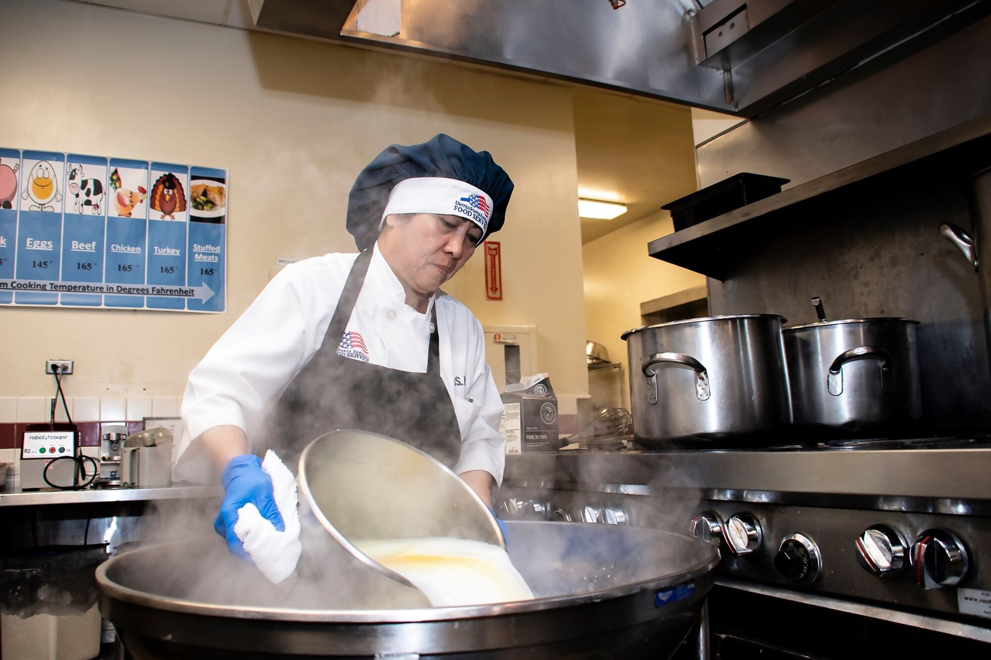 Praxedes Miller, 60th Force Support Squadron cook, makes a serving of mashed potatoes before a lunch service March 11, 2020, at Travis Air Force Base, California. Miller’s more than 30 years of kitchen experience come in handy during the base’s meal services, which support thousands of Airmen. (U.S. Air Force photo by Senior Airman Christian Conrad)