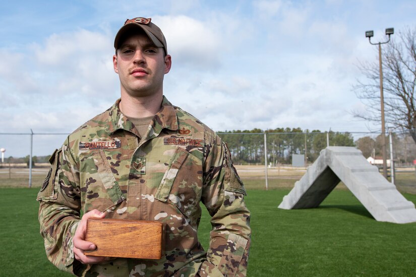 A man holds a wooden box.