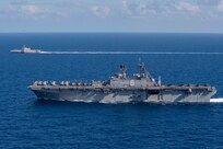 Amphibious assault ship USS America (LHA 6) sails alongside littoral combat ship USS Gabrielle Giffords (LCS 10).