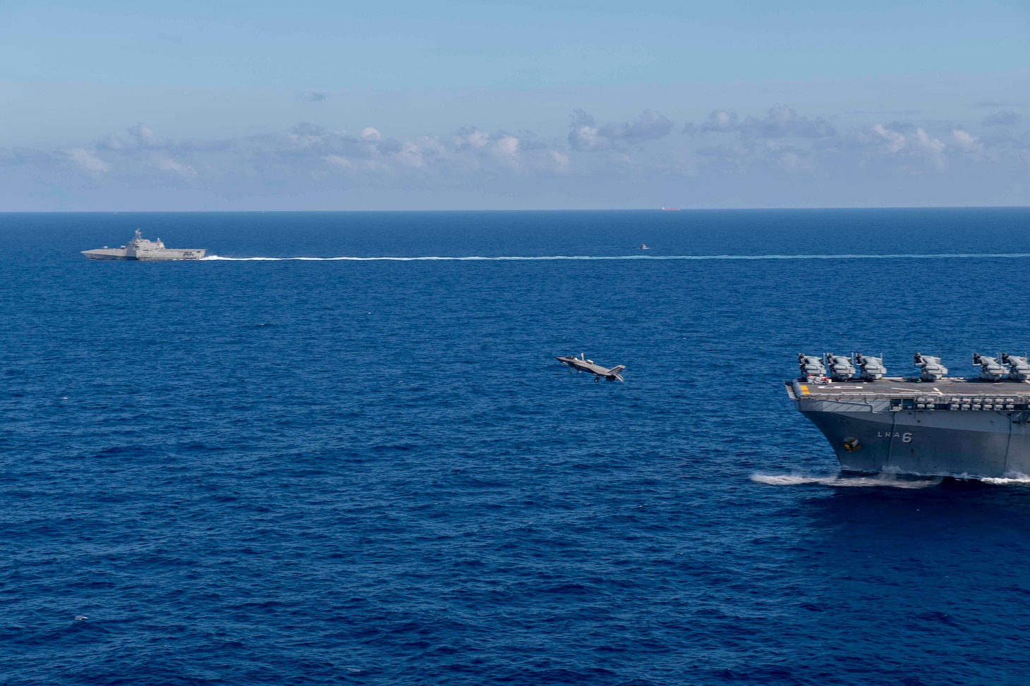 Amphibious assault ship USS America (LHA 6) sails alongside littoral combat ship USS Gabrielle Giffords (LCS 10).