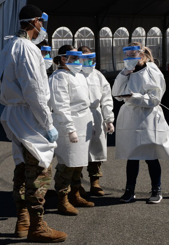 Guardsmen in medical garb receive briefing.