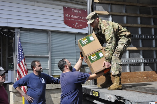 Guardsman unloads supplies from truck.