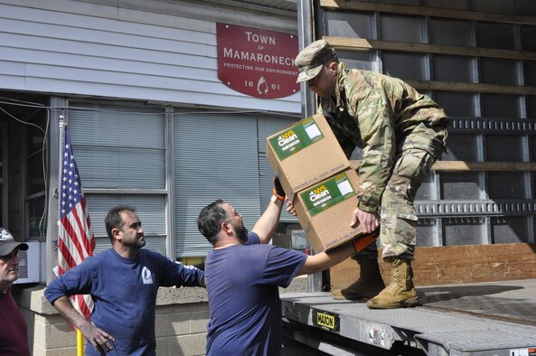 Guardsman unloads supplies from truck.