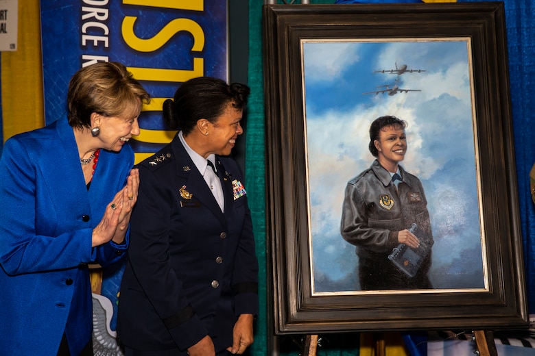Secretary of the Air Force Barbara Barrett and Lt. Gen. (ret.) Stayce Harris look on at the unveiling of Harris' painting at the Women in Aviation International conference
