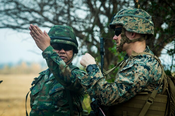 A Royal Thai Marine talks with a U.S. Marine during a combined joint High Mobility Artillery Rocket System rapid insertion as part of Cobra Gold 2020, at Chandy Range Kingdom of Thailand, March 2.