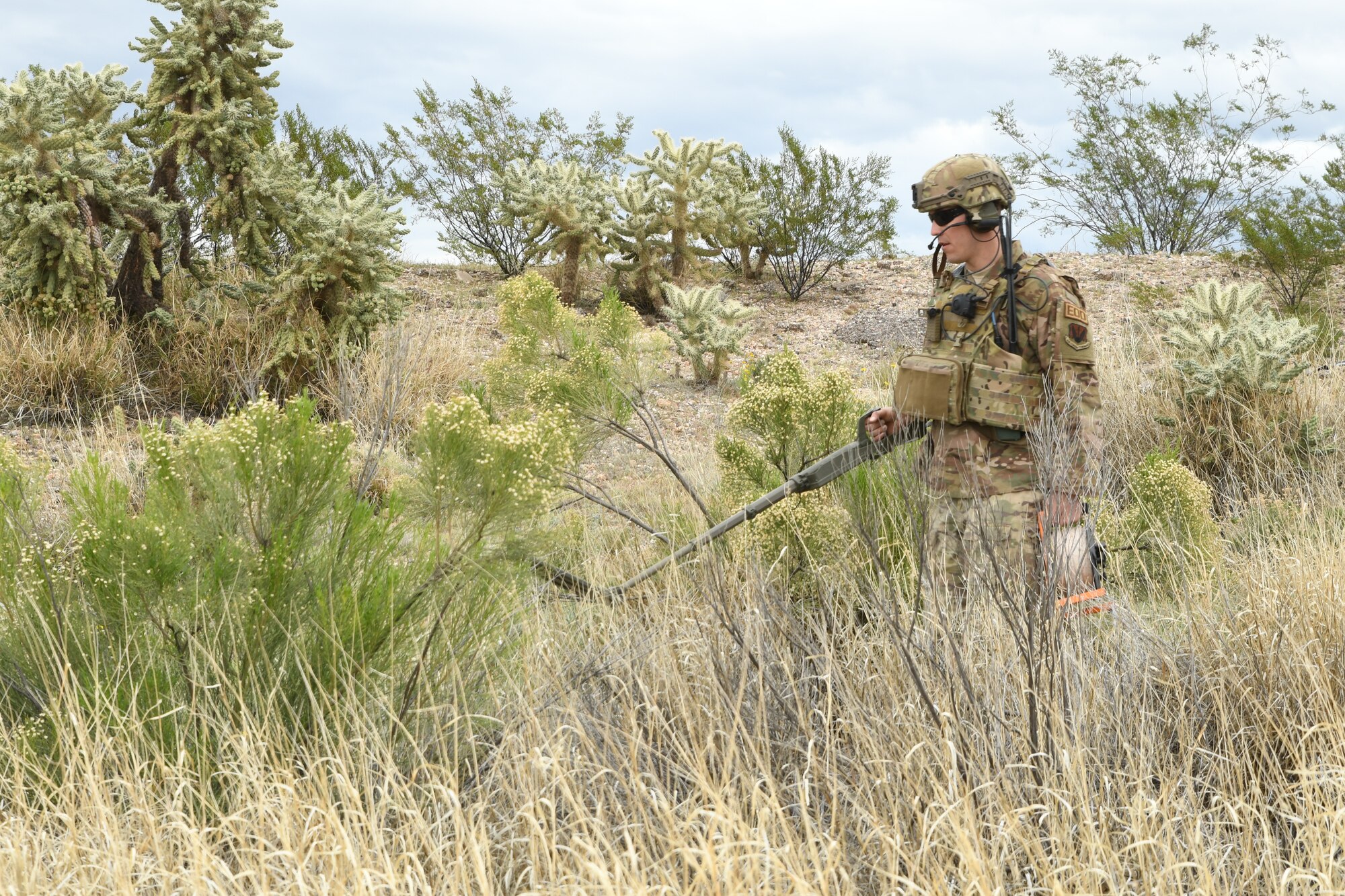 A photo of an airman with a metal detector
