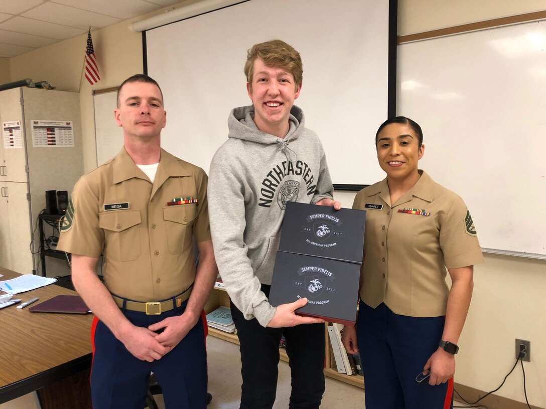Staff Sgt. Jeffrey Mega, a recruiter with Recruiting Substation Bend, Recruiting Station Portland and Staff Sgt. Iris Suarez, Staff Non-Commissioned Officer in Charge of RSS Bend, present the Semper Fidelis All-American Award to Jacob Ashby, a Junior at Mountain View High School in Bend, OR. The Semper Fidelis All-American Program selects students to attend the "Battles Won Academy" in Washington DC.