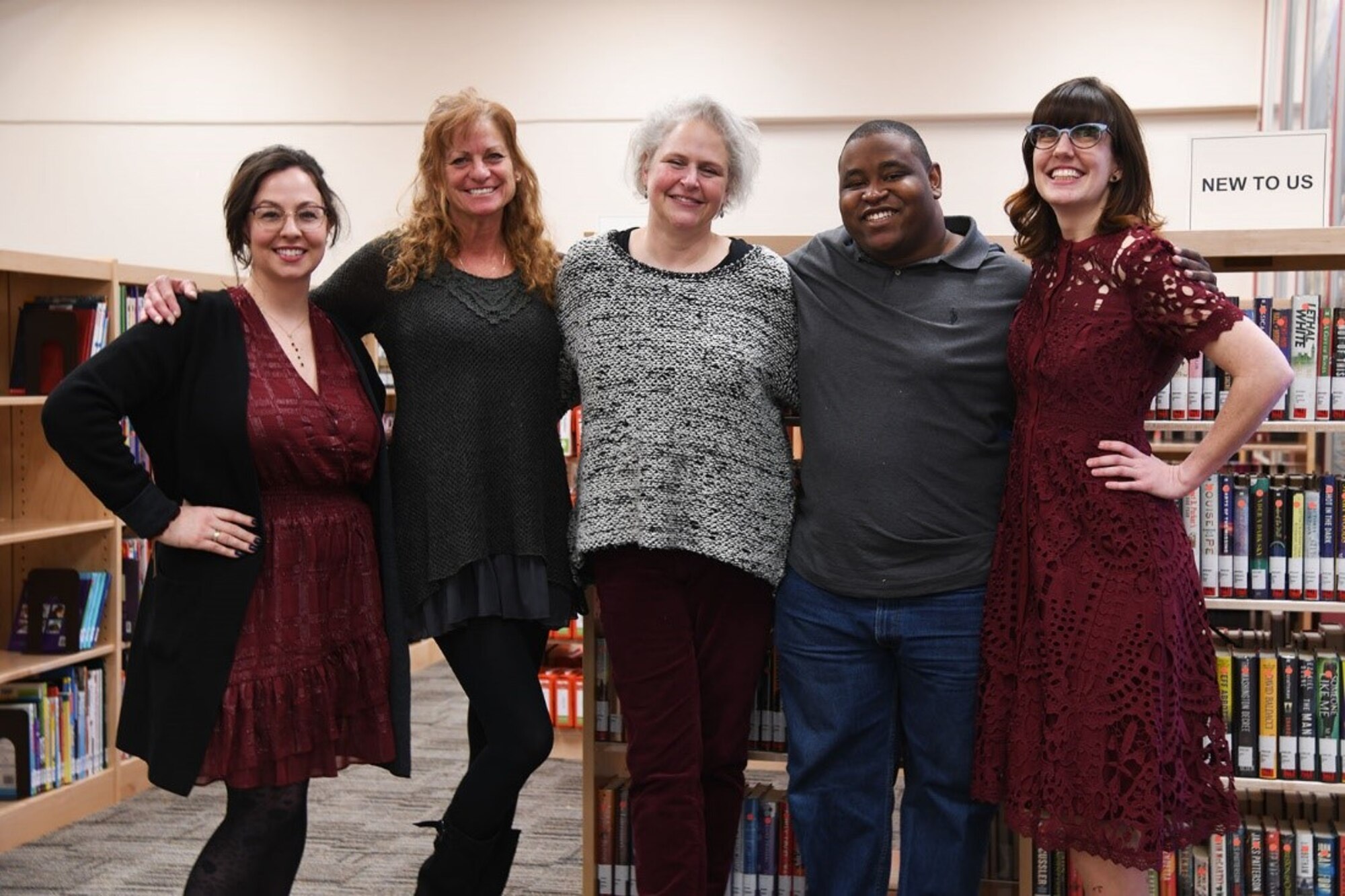 Library staff pose for a photo March 5, 2020 in the newly renovated library on Peterson Air Force Base, Colorado. The library has been closed since November 2019 in order to install a new carpet as well as update the cataloging system to a new modern bookstore layout. (U.S. Air Force photo by Erica Blanton)