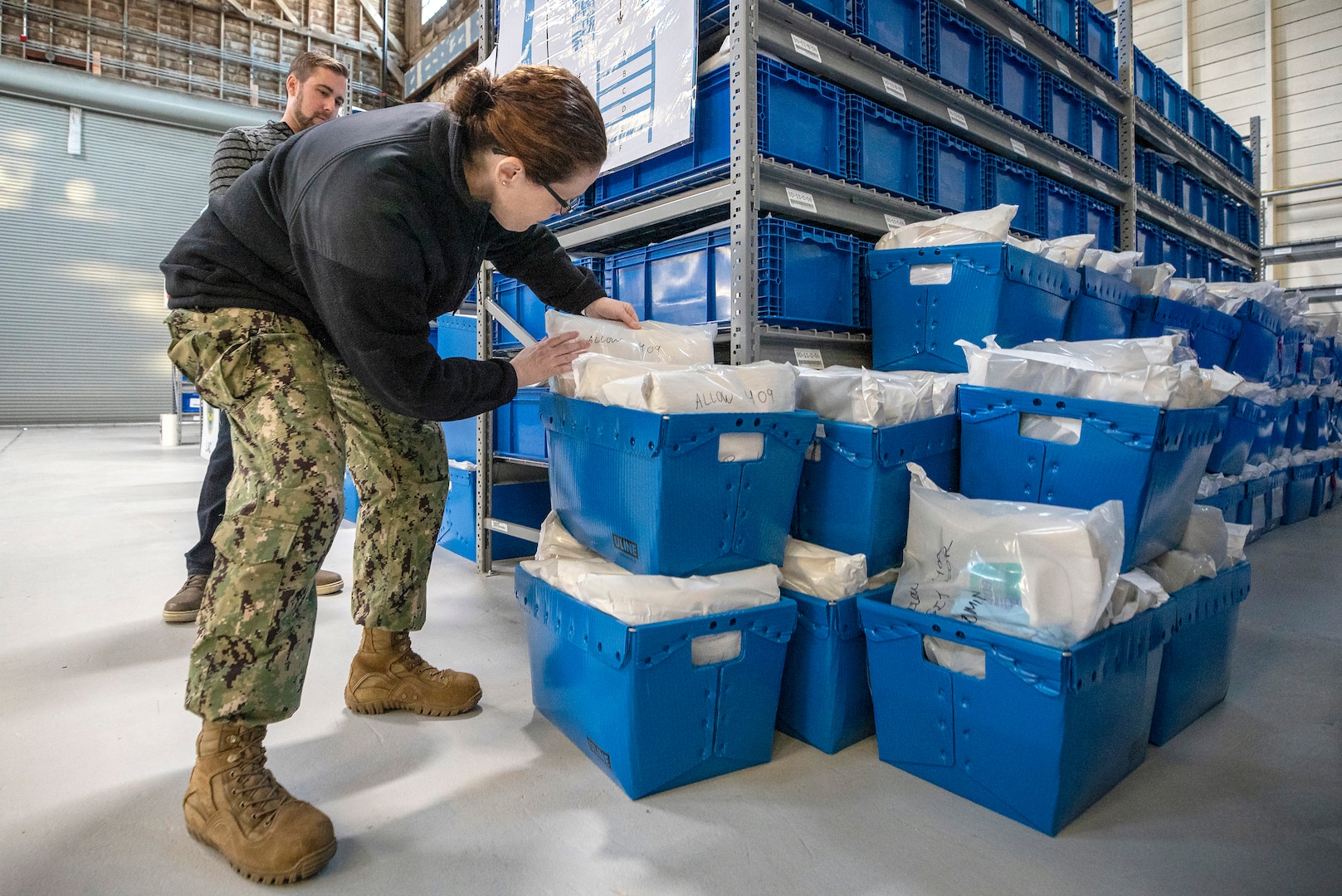 Capt. Dianna Wolfson, commander, Puget Sound Naval Shipyard & Intermediate Maintenance Facility inspects cleaning kits to be distributed through the shipyard. Employees from Puget Sound Naval Shipyard & Intermediate Maintenance Facility worked throughout the weekend to put together more than 2,000 cleaning kits to use around the command in an effort to amplify sanitation efforts during the COVID-19 pandemic.
