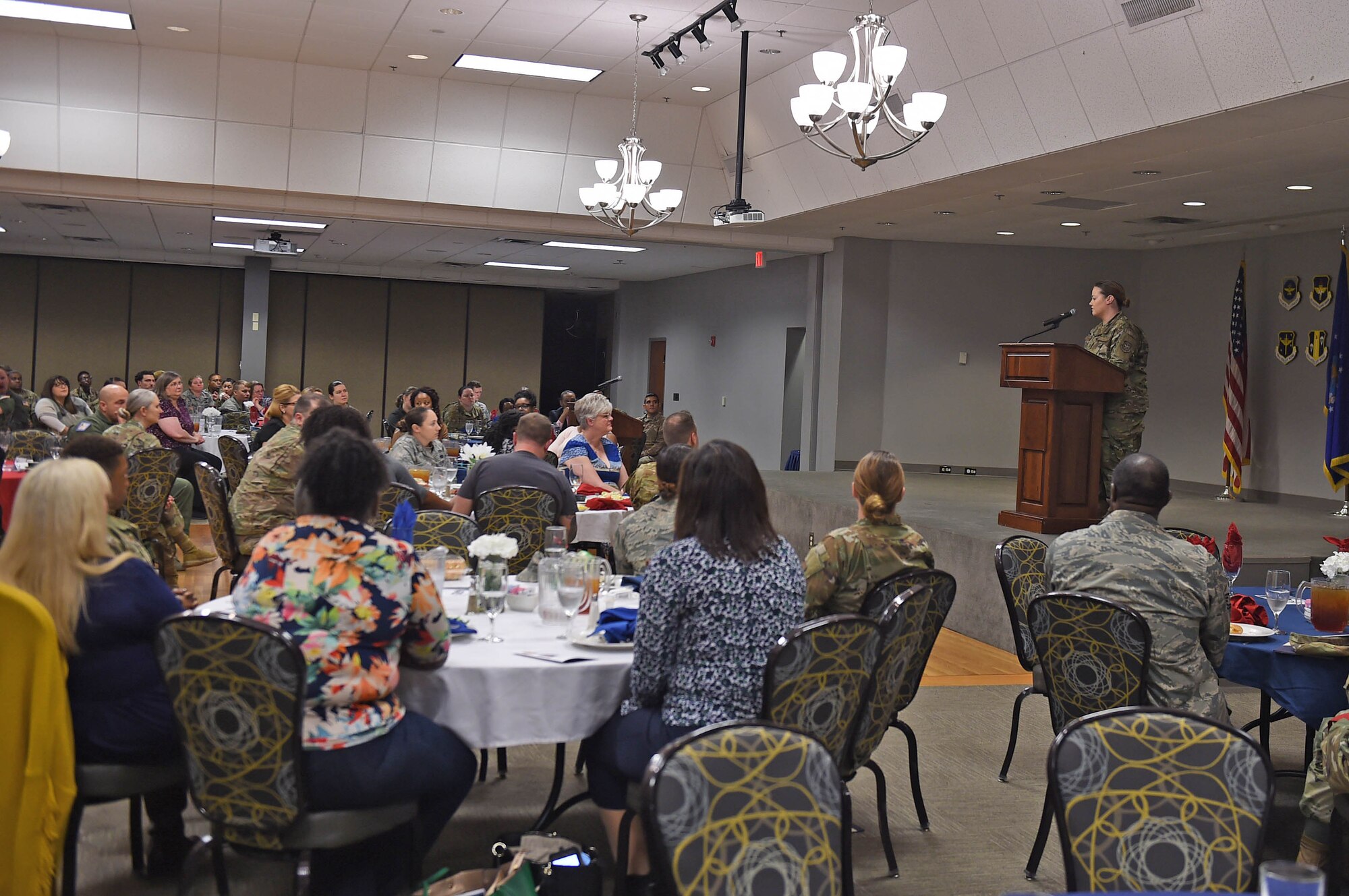 A person speaks to a large audience