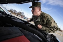 Navy Chief Damage Controlman Kevin Fischbach, assigned to the Joint Task Force Civil Support (JTF-CS) operations department, performs a weekly maintenance check on one of the command’s deployable vehicles.