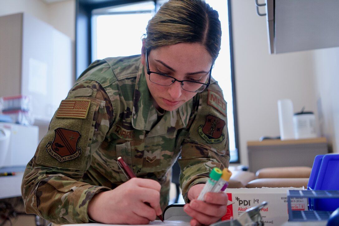 Alaska Air National Guard Senior Airman Loida Torres Román, a 176th Medical Group health-systems technician, logs lab samples at Joint Base Elmendorf-Richardson, Alaska, March 13, 2020. Torres Román earned national top honors as the Air National Guard’s Aerospace Medicine Airman of the year for 2019. (U.S. Air National Guard photo by David Bedard)
