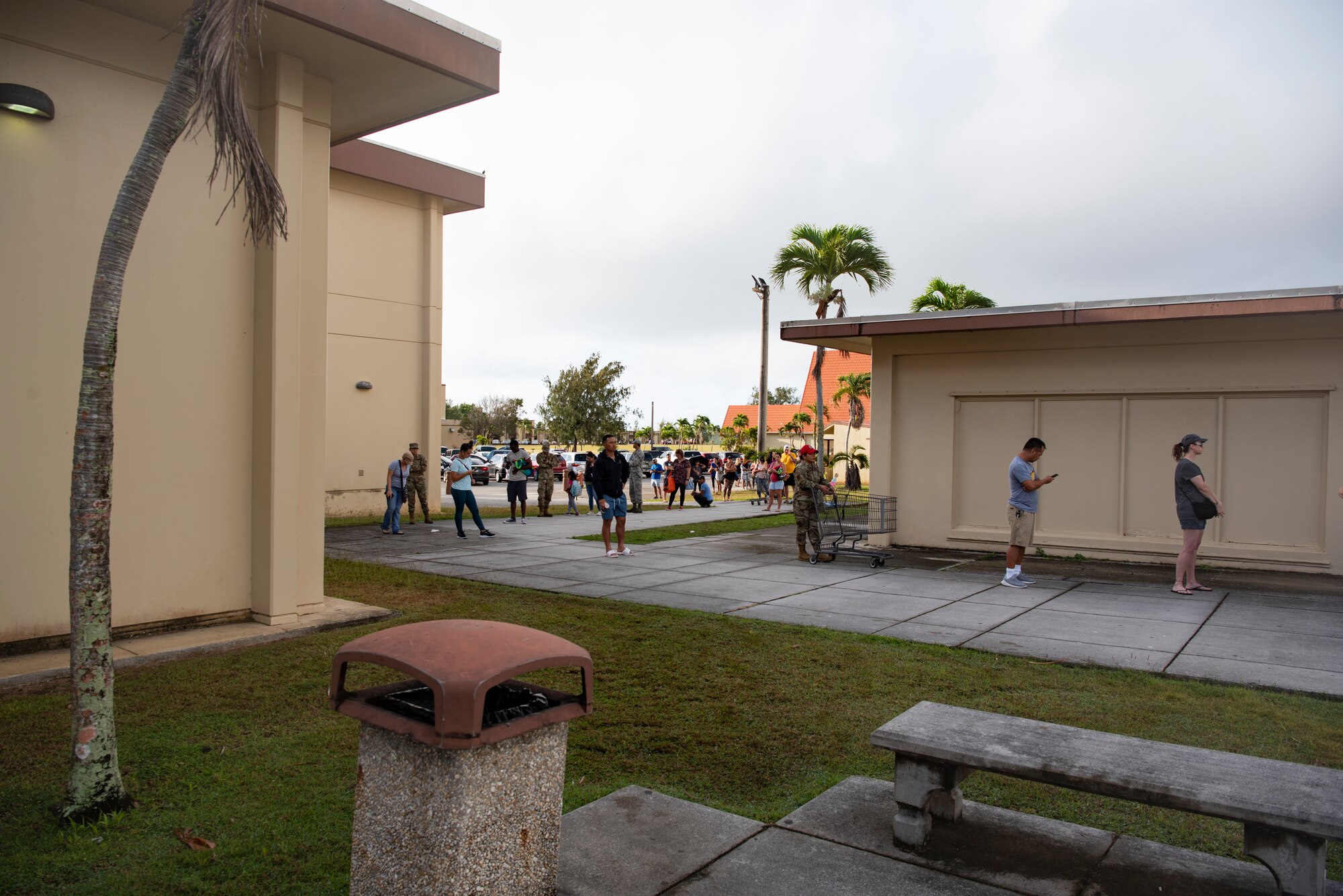 Service members and spouses assigned to Andersen Air Force Base and Naval Base Guam wait in line to enter the Andersen Commissary at AAFB, Guam, March 17, 2020.