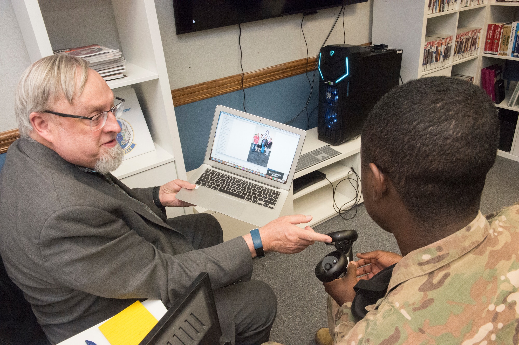 Adrian Clive, 818th Mobility Support Advisory Squadron command language education program manager (left), explains future plans for the Language Learning Center with Airman 1st Class Etchy Tambe (right), 621st Contingency Response Squadron aerial porter journeyman, at Joint Base McGuire-Dix-Lakehurst, New Jersey, Mar. 3, 2020. The LLC was created to help Airmen from the 818th Mobility Support Advisory Squadron maintain French language proficiency for their frequent trips to Africa in support of developing air mobility capabilities. (U.S. Air Force photo by Staff Sgt. Sarah Brice)