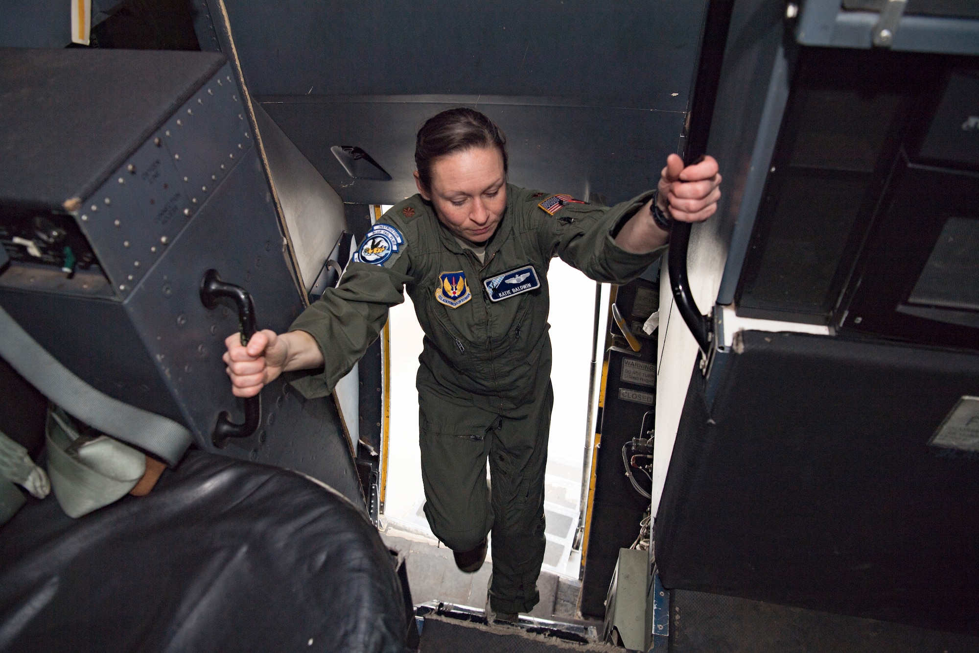 U.S. Air Force Maj. Mary Baldwin, 37th Airlift Squadron C-130J Super Hercules aircraft pilot, climbs onto a C-130J flight deck.