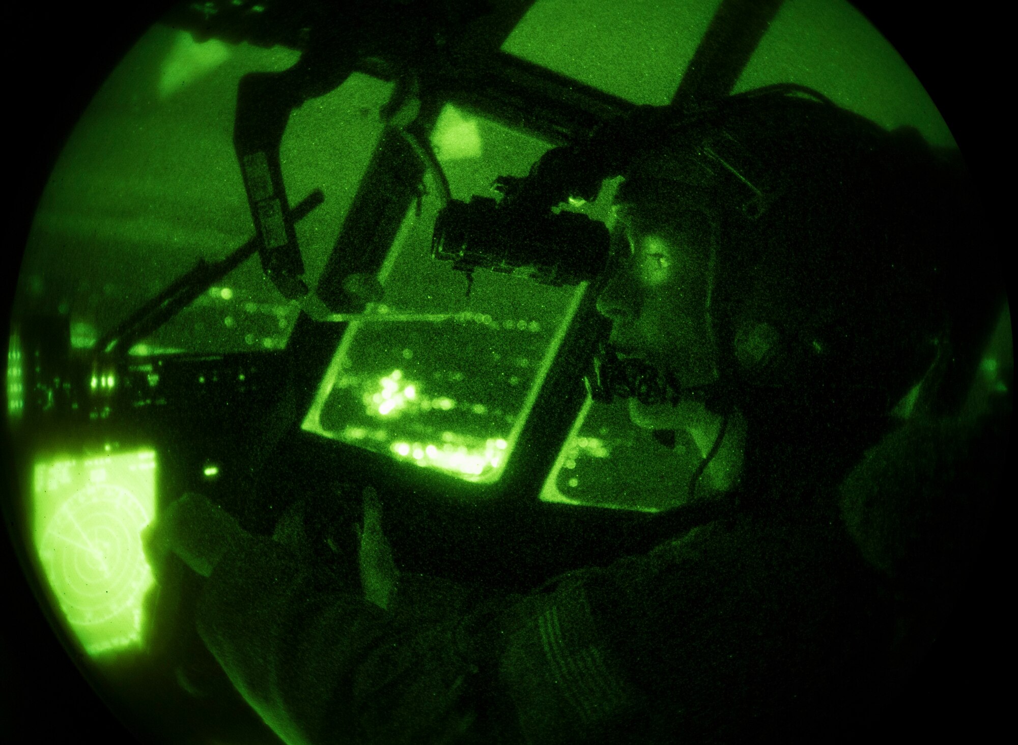 U.S. Air Force Maj. Mary Baldwin uses night vision equipment to fly a C-130J Super Hercules aircraft at night.