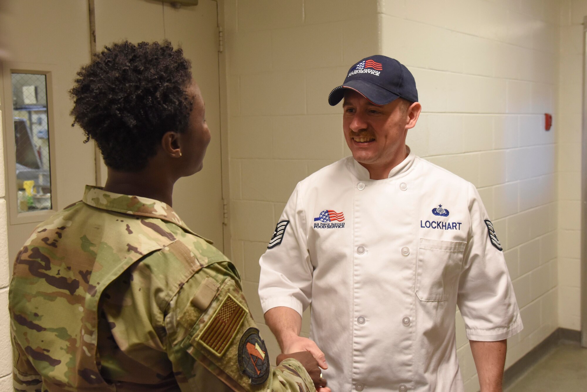 Col. Angenene Robertson, Air Mobility Command director of manpower, personnel and services, presents her coin to Tech. Sgt. Emmanuel Lockhart, 436th Force Support Squadron noncommissioned officer in charge of the Patterson Dining Facility, March 12, 2020, at Dover Air Force Base, Delaware. Robertson visited the base for a Dover AFB force support immersion where she learned in-depth details about each organization’s mission and day-to-day operations, including the Air Force Mortuary Affairs Operations. (U.S. Air Force photo by Senior Airman Eric M. Fisher)