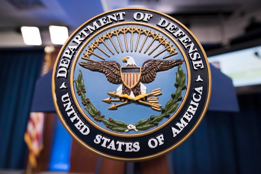 Closeup view of the Defense Department seal on a lectern.