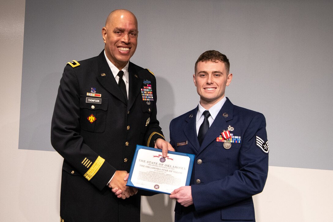 Maj. Gen. Michael Thompson (left), adjutant general for Oklahoma, and Staff Sgt. Benjamin Anderson (right), an air freight journeyman assigned to the 137th Special Operations Logistics Readiness Squadron, pose with the Oklahoma Star of Valor award during a ceremony March 7, 2020, at Will Rogers Air National Guard Base, Oklahoma City. Anderson was honored for his heroic actions when he saved a man from a burning vehicle April 29, 2018.