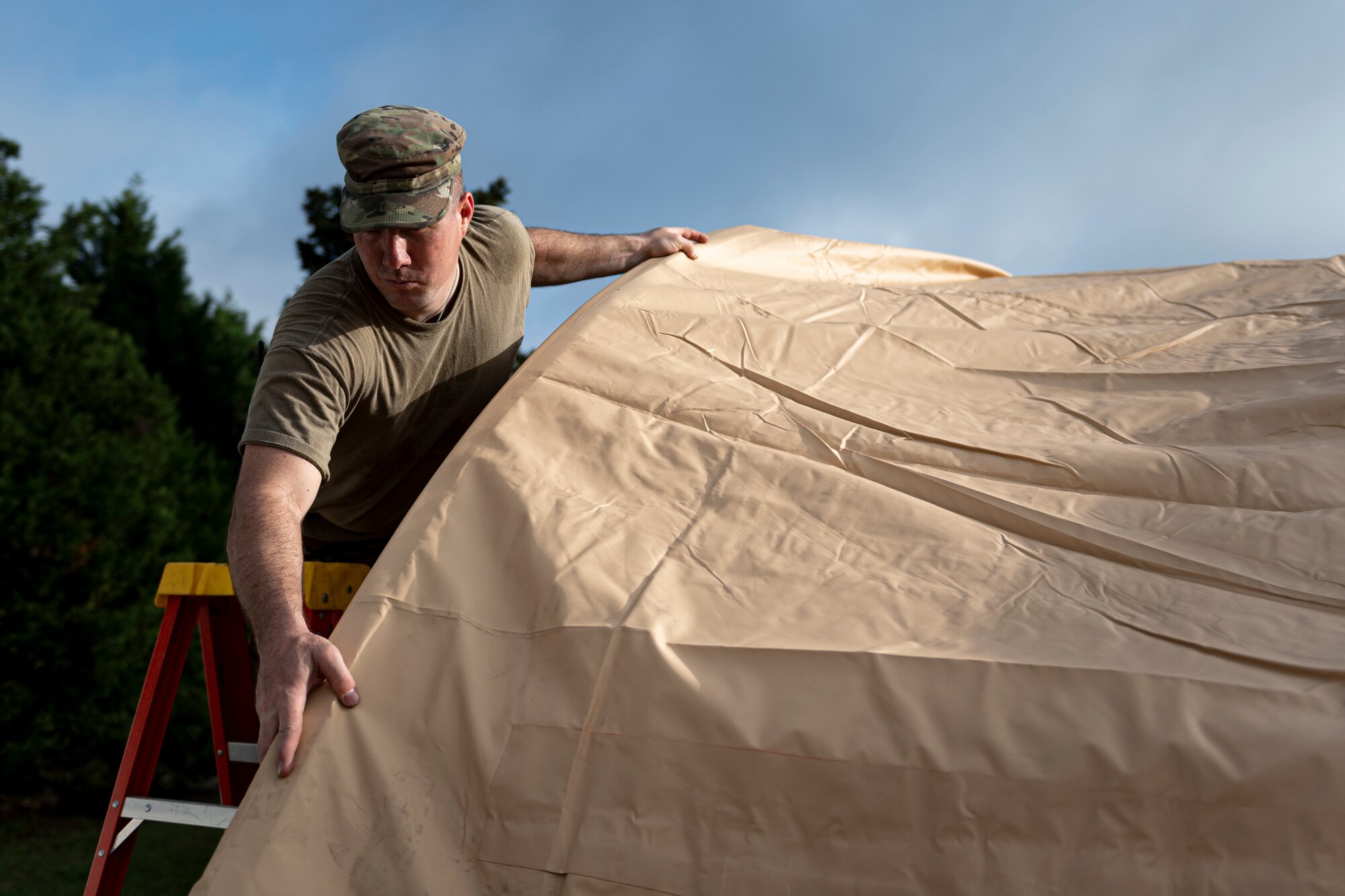 A photo of an Airman setting up a tent