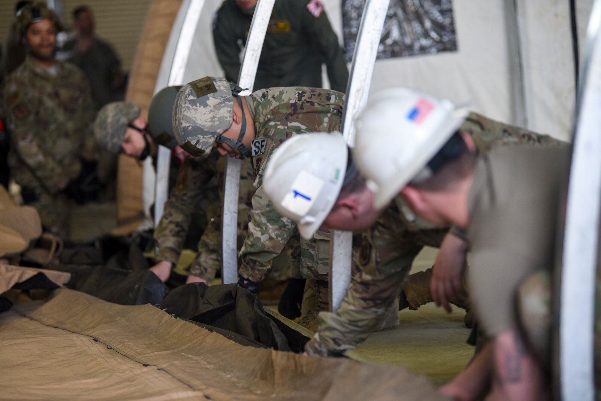 U.S. Airmen from various unit of the 35th Fighter Wing work together to build a small shelter system tent during an Agile Combat Employment practice capstone event at Misawa Air Base, Japan, March 13, 2020. The ACE concept requires units to deploy small teams to austere locations. As such, Airmen are training to be able to assist in completing tasks outside of their normal career functions. (U.S. Air Force photo by Tech. Sgt. Timothy Moore)