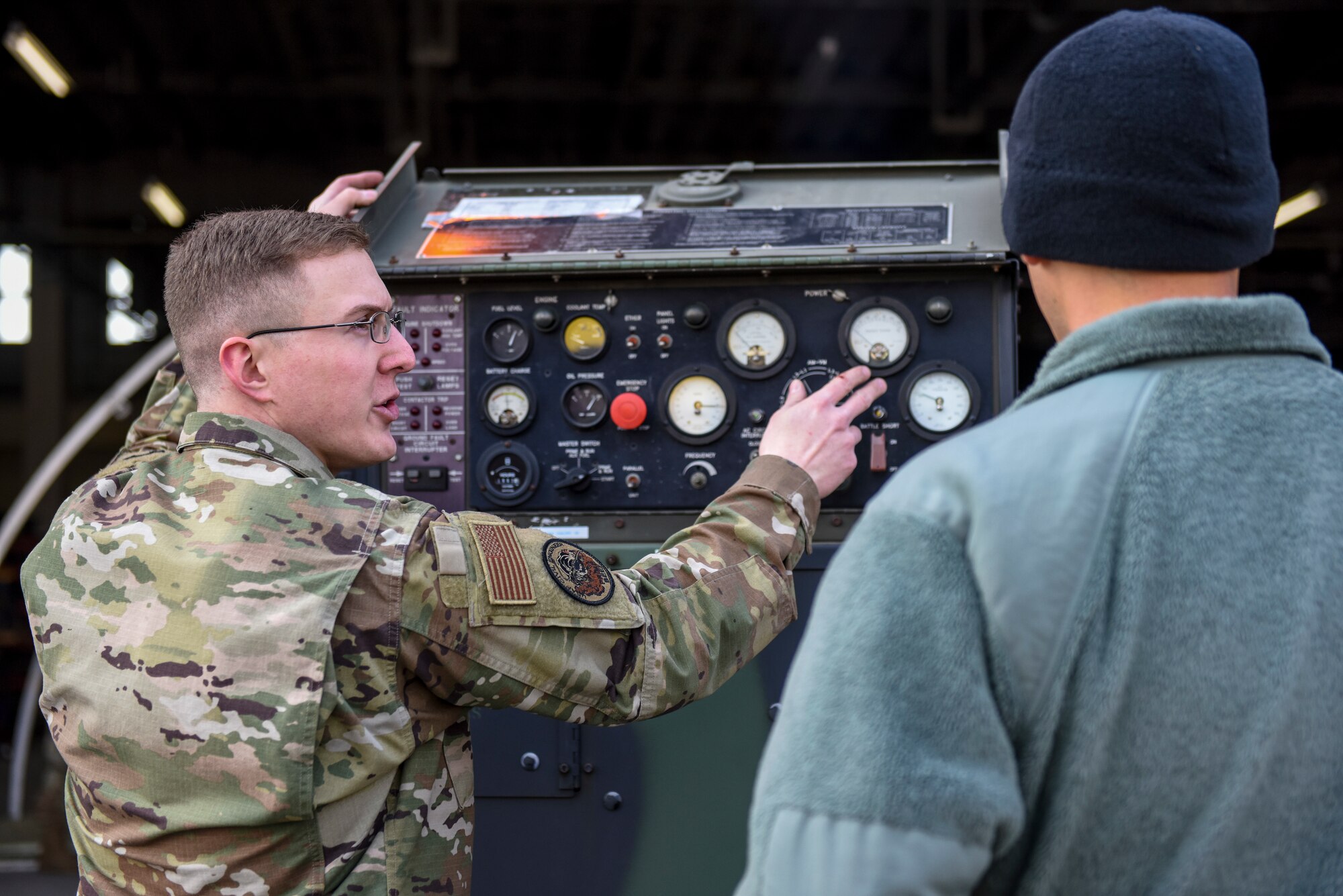 U.S. Air Force Staff Sgt. Tyler Robinson, a power projection journeyman with the 35th Civil Engineer Squadron, explains the controls on an MEP-806A generator to 1st Lt. Jordan Garcia, an assistant unit deployment manager with the 14th Fighter Squadron, during an Agile Combat Employment practice capstone event at Misawa Air Base, Japan, March 13, 2020. Under the ACE concept, whenever Airmen aren't working on their core task they will be able to assist subject matter experts in their duties. (U.S. Air Force photo by Tech. Sgt. Timothy Moore)
