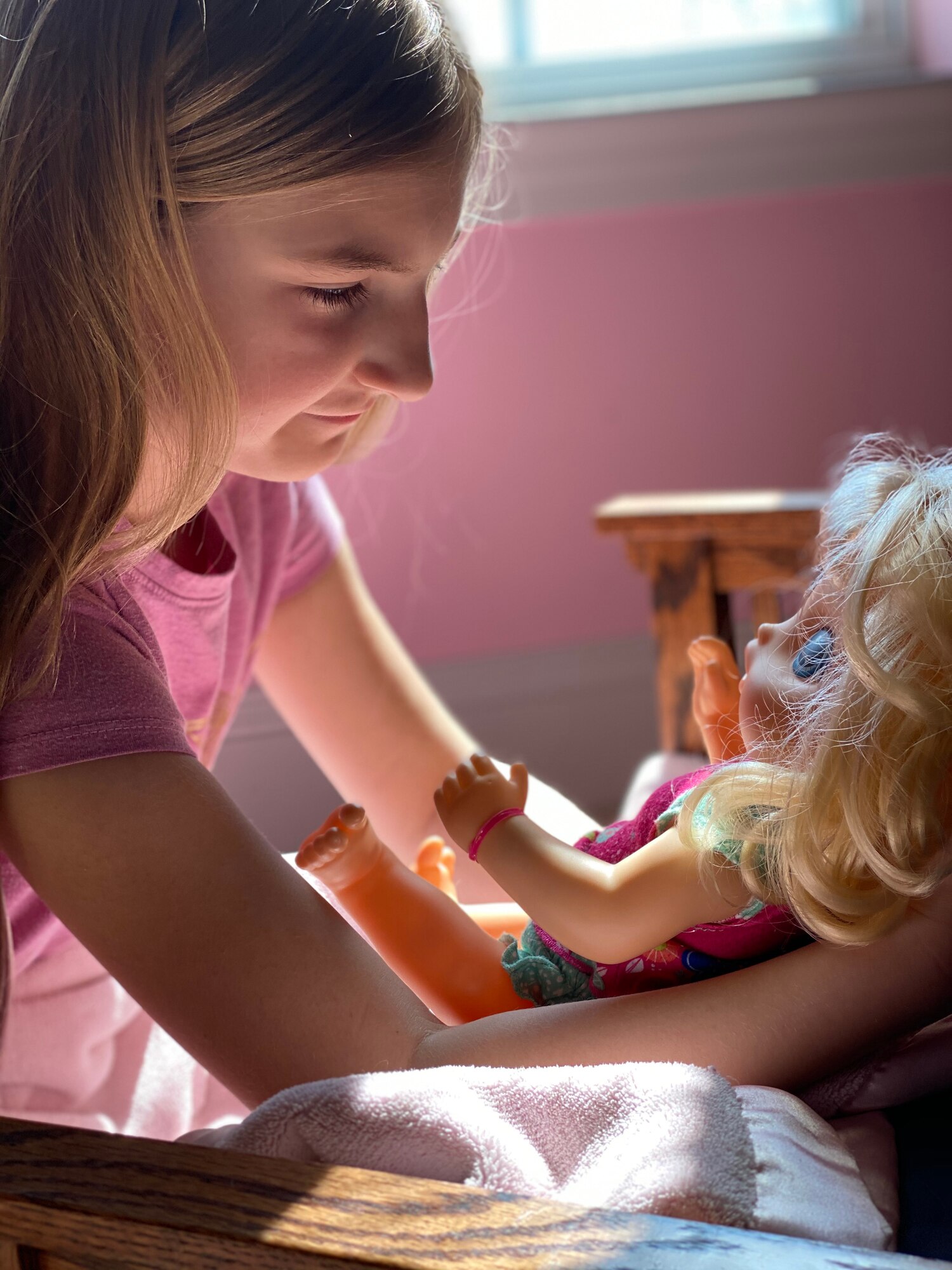 A girl plays with a doll.