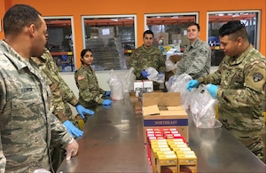 New York Air and Army National Guard members pack food parcels at a food pantry in Westchester County, N.Y., March 12, 2020, in support of state COVID-19 response efforts. Members were providing food to families to make up for school lunch and breakfast meals students are missing after schools in New Rochelle were closed to prevent the spread of the virus. (Photo by Col. Steve Rowe)