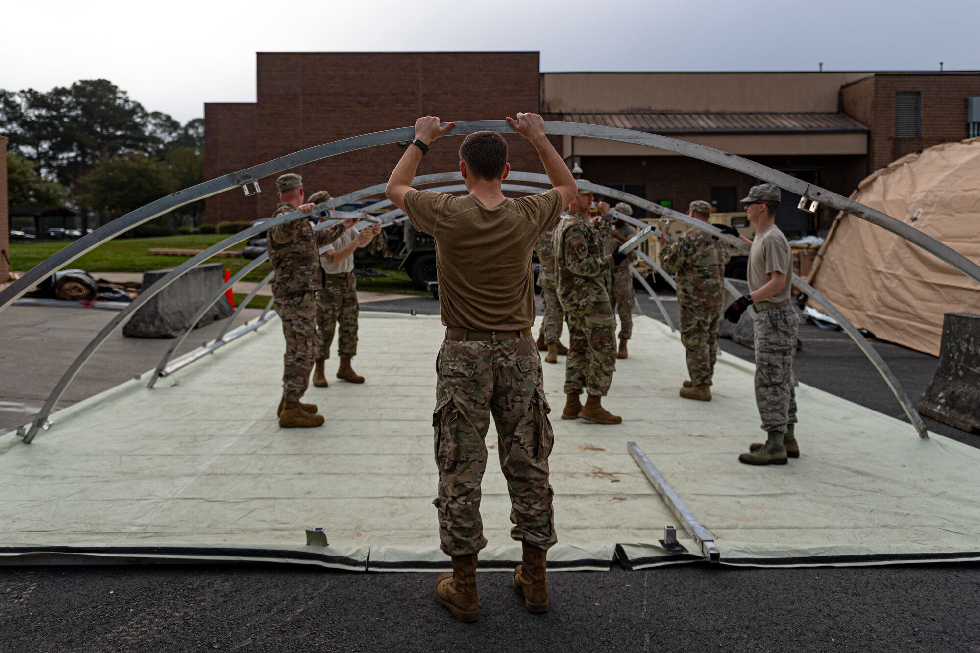 U.S. Air Force Airmen with the 23d Civil Engineer Squadron assemble a tent at Moody Air Force Base, Georgia, March 12, 2020. The 23d CES constructed tents to help facilitate the 23d Medical Group with screening active duty Airmen for COVID-19. (U.S. Air Force photo by Airman 1st Class Taryn Butler)