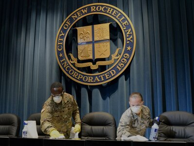 Spc.Sherman Bristol, left, a member of the New York Army National Guard's 4th Finance Detachment, and Airman 1st Class Nieves with the New York Air National Guard’s 106th Rescue Wing, help clean City Hall  in New Rochelle, New York, March 14, 2020. New York Army and Air National Guard members are supporting the multi-agency response to COVID-19.