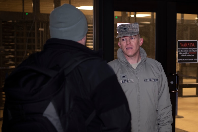 Col. Brian Kehl, 50th Mission Support Group commander, directs a member of Team Schriever at the entrance to the North Portal at Schriever Air Force Base, Colorado, March 18, 2020. Representatives tested mission essential personnel for fevers and other col symptoms before granting admittance into the restricted area. (U.S. Air Force photo by Airman 1st Class Jonathan Whitely)
