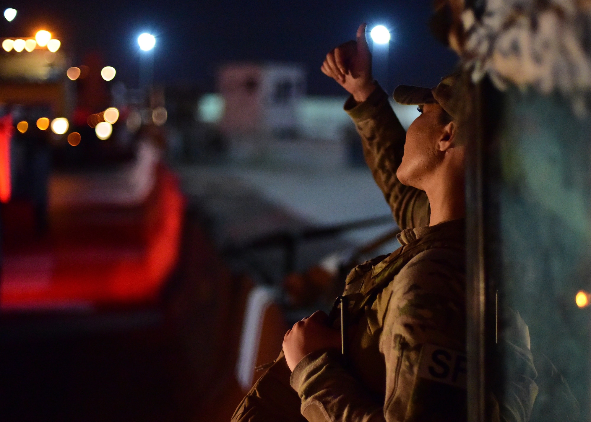 Airman signals to a vehicle convoy