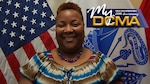 Smiling woman stands in front of flags