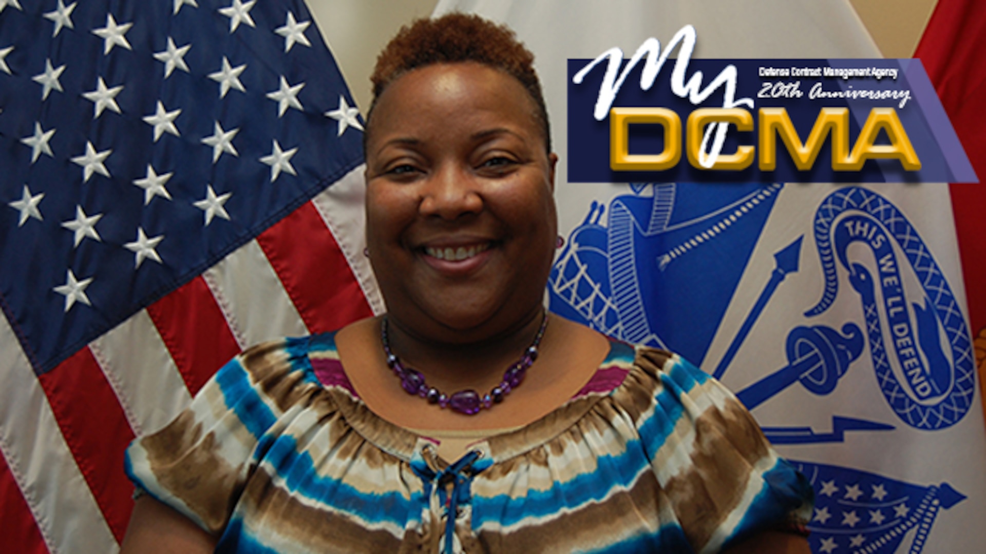 Smiling woman stands in front of flags