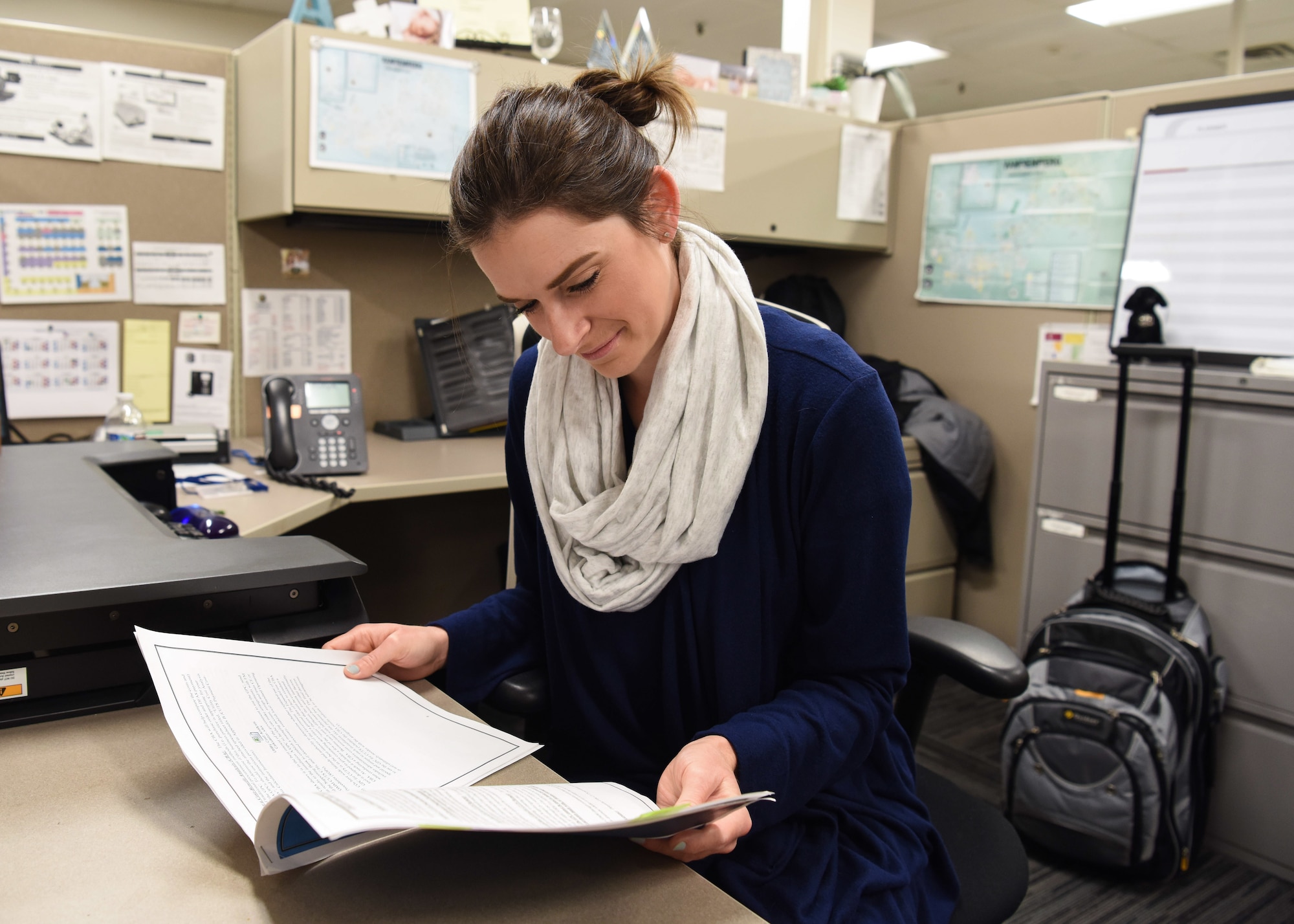 Photo of woman reading documents at a desk.