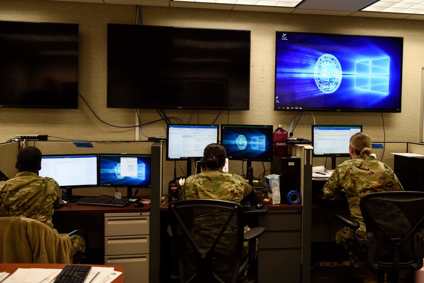 Photo of Airmen working at their desk.