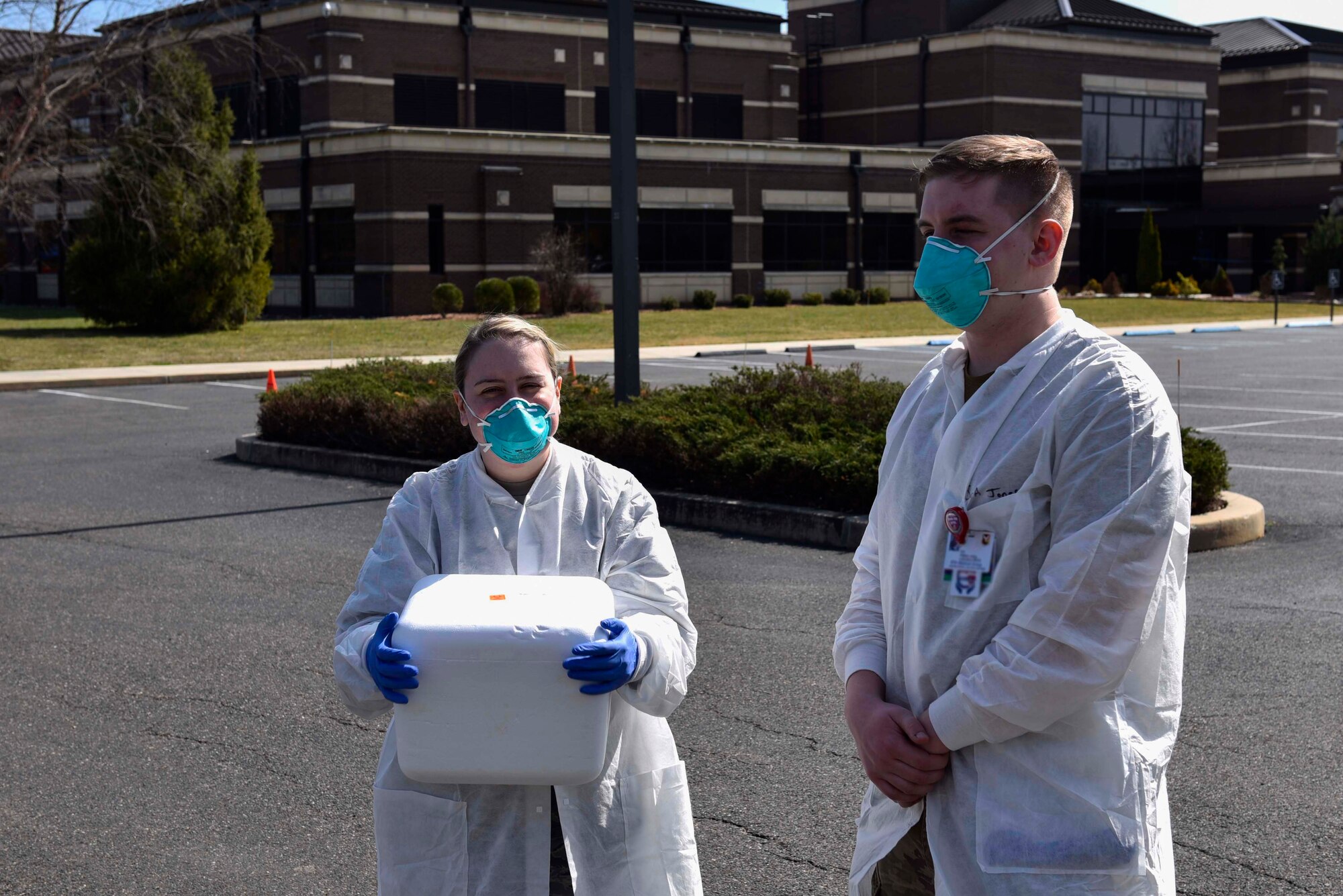A photo of two Airmen standing in a parking lot.
