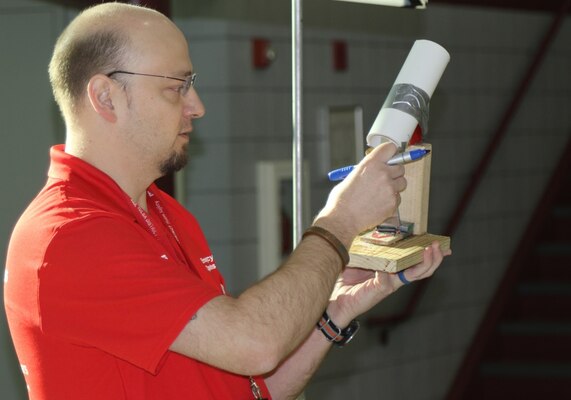 Christopher Strunk, chief of military design, Tulsa District, U.S. Army Corps of Engineers reviews a ping pong ball launcher submission entry during the 2020 Tulsa Engineering Challenge at Tulsa Technical Institue, March 6.