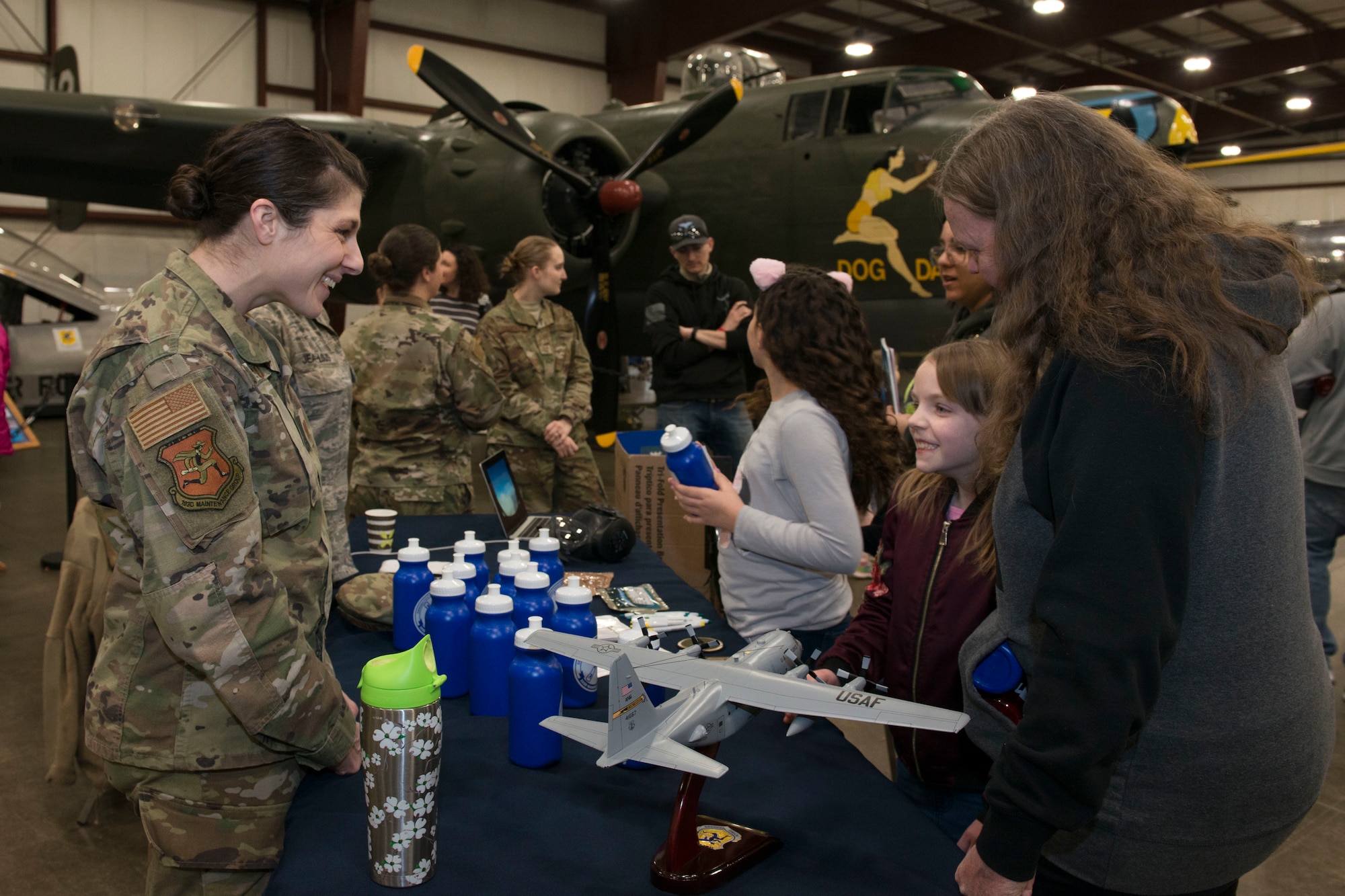 Air Force Capt. Jennifer Artiaco speaks with a girl about the Air National Guard at the annual "Women Take Flight" event held at the New England Air Museum, Windsor Locks, Connecticut, March 7, 2020. "Women Take Flight" is targeted toward girls who are interested in avionics and other STEM related fields.(U.S. Air National Guard photo by Tech. Sgt. Tamara R. Dabney)
